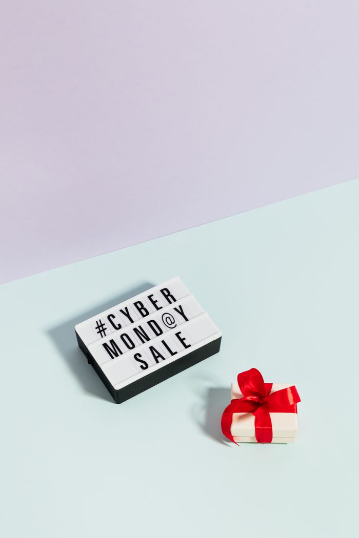 services-01 Minimalist setup showing a Cyber Monday sale sign and a gift box with a red bow.