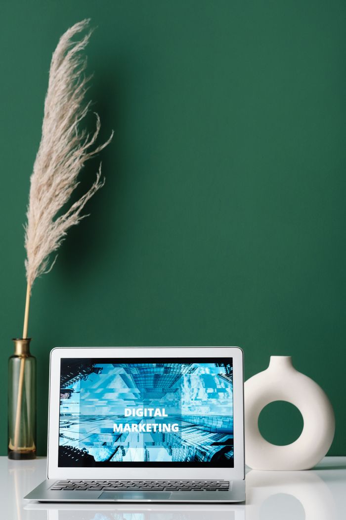 services-02 Laptop displaying digital marketing on screen with decorative items on a desk.