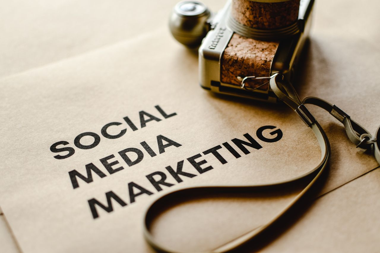 services-01 Close-up of a camera placed on brown paper with 'Social Media Marketing' text, emphasizing digital marketing themes.